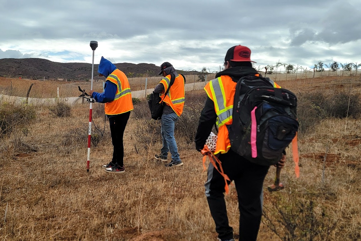 Brigada de topografía de ACACIA recorriendo el predio en jornada de campo